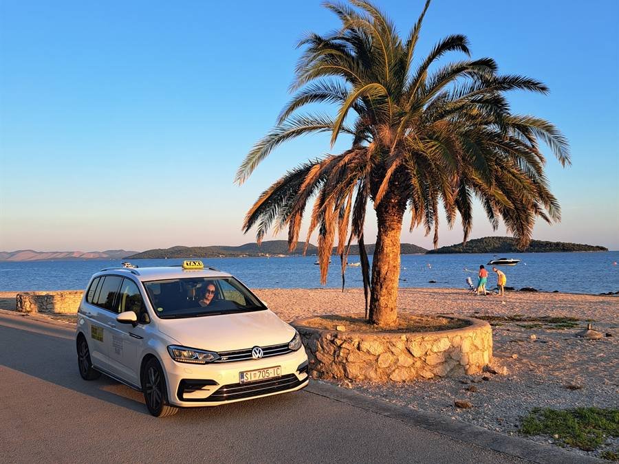 Vozilo Taxi Ana Vodice uz palmu u zalazak sunca